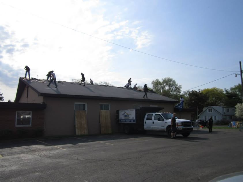 A large volunteer crew replacing the roof at Open Arms Church in May 2013